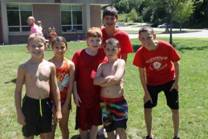 (l to r) Campers Brady Chapman, Tianna Davoodi, Ben Bartlett and James Barry dry off after cooling down on the waterslide with junior staff members Elliot Mintz (left) and Tim Barry.