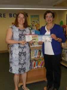 Maureen Ambrosino, library director, accepts museum passes from Judy Wilchynski, president, Friends of the Westborough Public Library. (Photo/submitted)