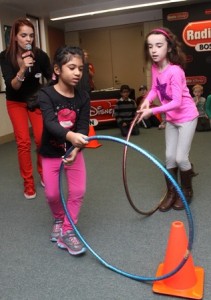 Kealy Faye, 8, and Sarah Farick, 5, both of Westborough, roll hula hoops as part of a game.