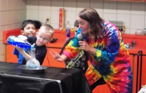 Brooks is instructed by Shoshana when to stop pouring in the bubbles during the  Sciencetellers performance at the Westborough Public Library. Photo/Gregory Arnold 