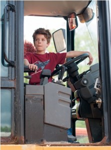 Nolin Vangel, 6, from Scituate, climbs aboard a large construction vehicle.   