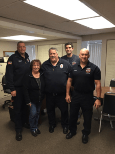Patty Zilembo, director of Countryside Village, assists Marlborough firefighters (left to right) Ron Percy, Bob Dolan, Jay DeGiacomo, and Dave Logan with deliveries of Thanksgiving dinners to local families who were financially unable to provide for themselves.   (Photo/submitted)