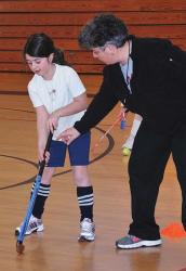 Thirdgrader Isabella Sciplini receives instruction from Paula Toti, the assistant coach of the Shrewsbury High School Field Hockey team. PHOTO/ED KARVOSKI JR.