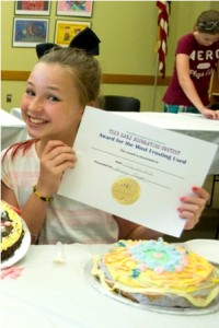 Sarah proudly shows off her cake and award for "Most Frosting Used" at the contest. 