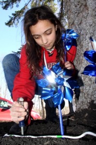 Chloe Reeve-Patel, 11, plants a pinwheel at the Pinwheels For Prevention garden outside Northborough Town Hall on Saturday. The purpose of the garden is to create awareness of Child Abuse Prevention Month.