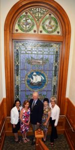 As part of the renovation, the library’s treasured stained glass window from 1904 was dismantled, shipped across the state, and completely restored. Posing with the window are (l to r) Priya Rathnan, Mary Casey, Matt Hogan, Laurie Hogan and Ellen Dolan. 