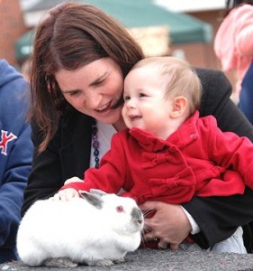 Anouk Chevalier and her daughter, Anais, 14 months, pet a rabbit following a magic show performed at the pavilion at Bay State Green. (File photo/Ed Karvoski Jr.) 